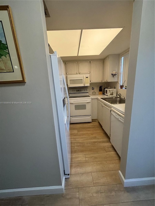 2929 SE Ocean Blvd Unit 125-3, Stuart, FL 34996 - kitchen with white appliances, light wood finished floors, and light countertops