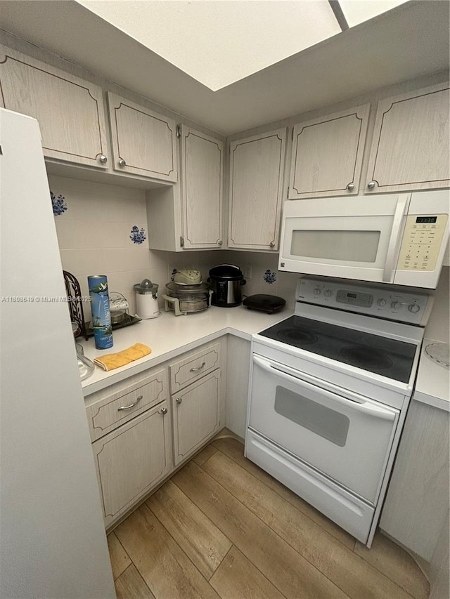 2929 SE Ocean Blvd Unit 125-3, Stuart, FL 34996 - kitchen with white appliances, light wood-style floors, and light countertops