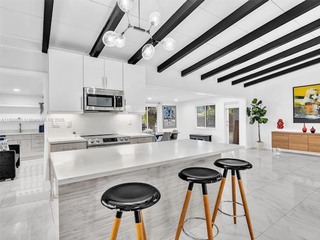 2454 W Nassau Ln, Fort Lauderdale, FL 33312 - kitchen with stainless steel appliances, a chandelier, light countertops, open floor plan, and a kitchen breakfast bar