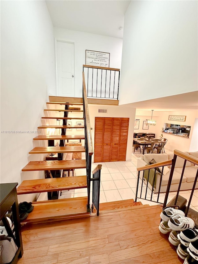 5975 SW 137th Ave Unit 902, Miami, FL 33183 - stairway featuring a towering ceiling, a chandelier, and tile patterned floors
