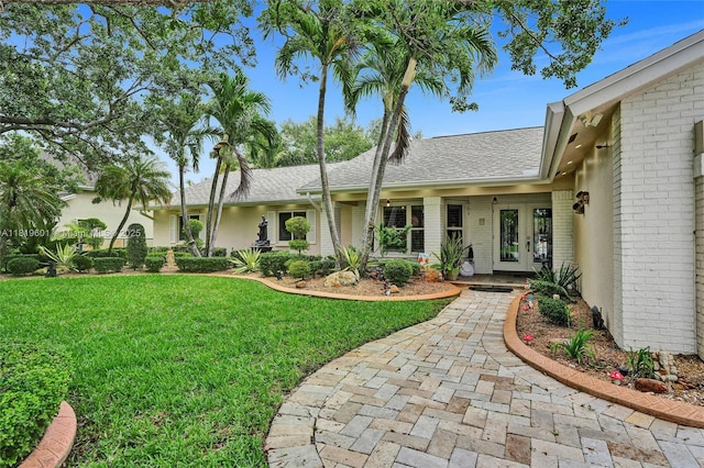 411 NW 201st Ave, Pembroke Pines, FL 33029 - view of front of property featuring french doors, brick siding, a front yard, and a shingled roof