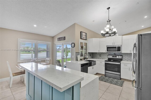 411 NW 201st Ave, Pembroke Pines, FL 33029 - kitchen featuring stainless steel appliances, vaulted ceiling, tasteful backsplash, a chandelier, and light tile patterned floors