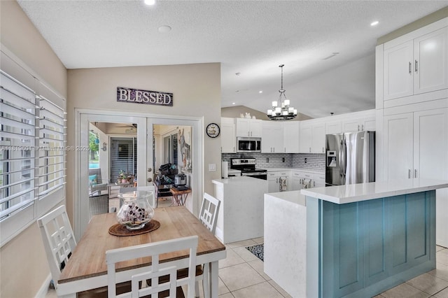 411 NW 201st Ave, Pembroke Pines, FL 33029 - kitchen featuring appliances with stainless steel finishes, light countertops, white cabinets, vaulted ceiling, and a chandelier