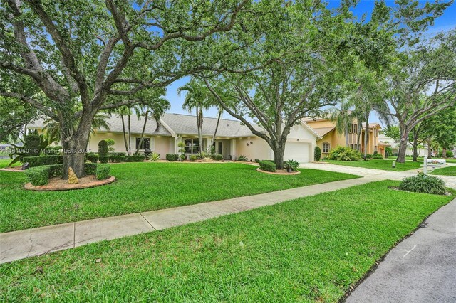 411 NW 201st Ave, Pembroke Pines, FL 33029 - view of front of house with stucco siding, driveway, an attached garage, and a front lawn