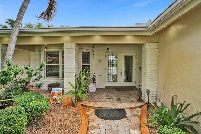 411 NW 201st Ave, Pembroke Pines, FL 33029 - view of exterior entry featuring brick siding, french doors, stucco siding, and a porch