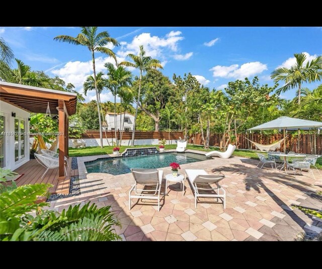 659 NE 73rd St, Miami, FL 33138 - view of pool featuring a fenced backyard, a deck, french doors, and a patio