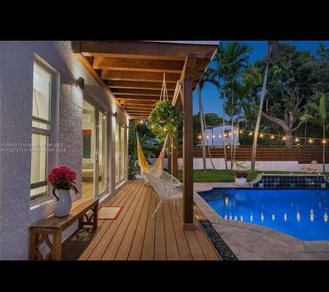 659 NE 73rd St, Miami, FL 33138 - pool at twilight featuring a fenced backyard and a wooden deck
