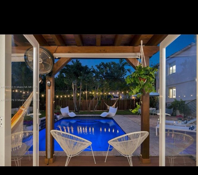 659 NE 73rd St, Miami, FL 33138 - pool at night with a fenced backyard and a patio area
