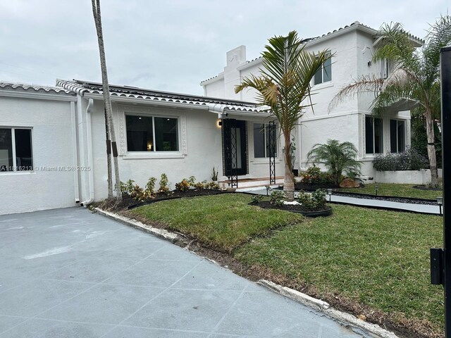 659 NE 73rd St, Miami, FL 33138 - view of front of house featuring stucco siding and a front lawn