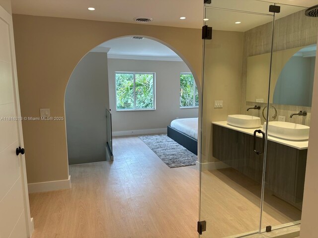 659 NE 73rd St, Miami, FL 33138 - ensuite bathroom featuring wood finished floors, double vanity, crown molding, recessed lighting, and tasteful backsplash