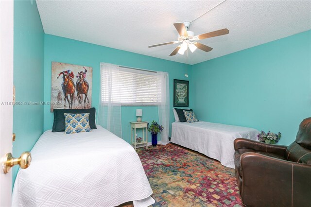 1001 NE 14th Ave Unit 107, Hallandale Beach, FL 33009 - carpeted bedroom featuring a ceiling fan and a textured ceiling