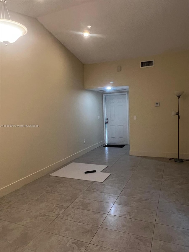 805 N Franklin Ave Unit 805D, Homestead, FL 33034 - spare room featuring baseboards, vaulted ceiling, and light tile patterned floors