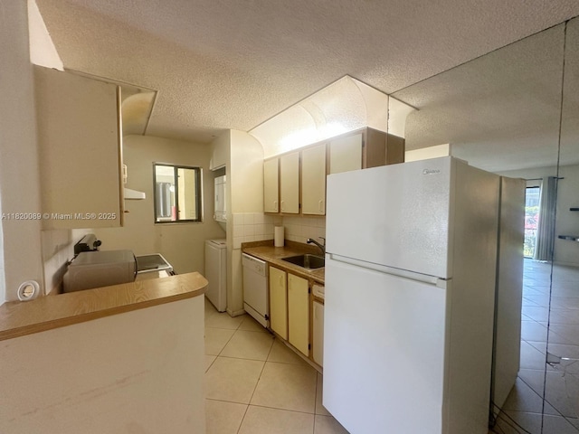 523 Trace Cir Unit 105, Deerfield Beach, FL 33441 - kitchen featuring white appliances, light tile patterned floors, a textured ceiling, washer / dryer, and light countertops