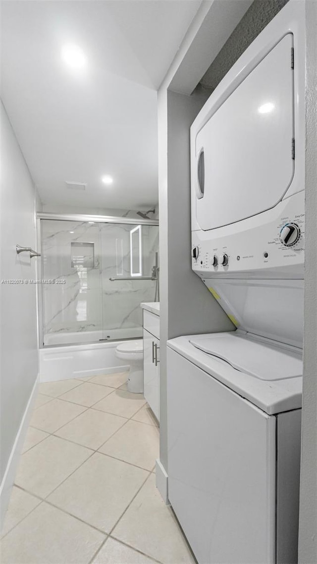 5550 NW 44th St Unit 205B, Lauderhill, FL 33319 - washroom with estacked washer and dryer, light tile patterned floors, and baseboards