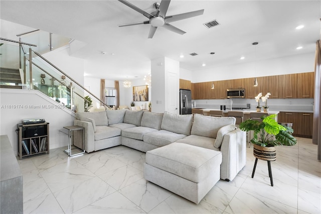17540 SW 46th St, Miramar, FL 33029 - living room with light marble finish floors, recessed lighting, stairs, ceiling fan, and a chandelier