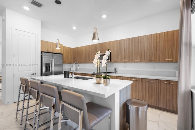 17540 SW 46th St, Miramar, FL 33029 - kitchen featuring stainless steel refrigerator with ice dispenser, brown cabinetry, light marble finish flooring, a sink, and modern cabinets