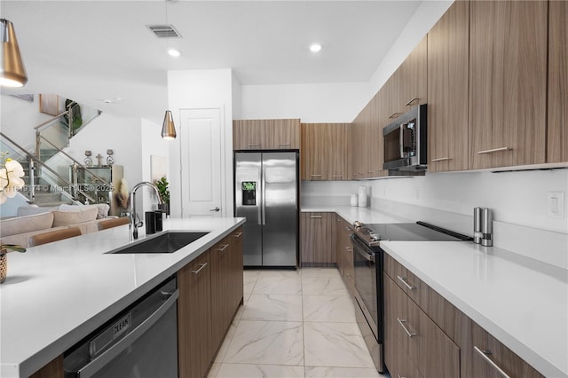 17540 SW 46th St, Miramar, FL 33029 - kitchen with appliances with stainless steel finishes, a sink, modern cabinets, light marble finish floors, and light countertops