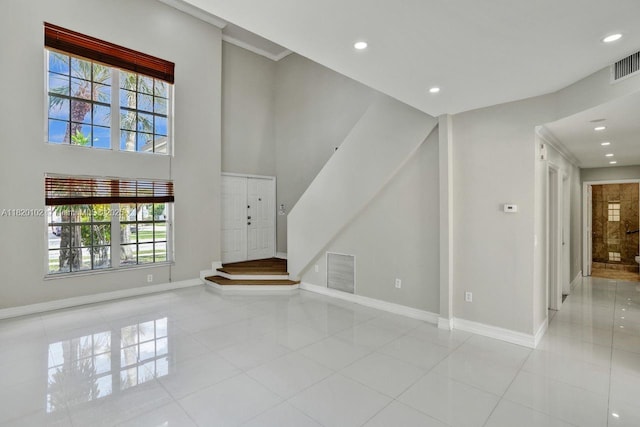 164 Granada Ave, Weston, FL 33326 - unfurnished living room featuring tile patterned floors, healthy amount of natural light, recessed lighting, stairway, and a high ceiling