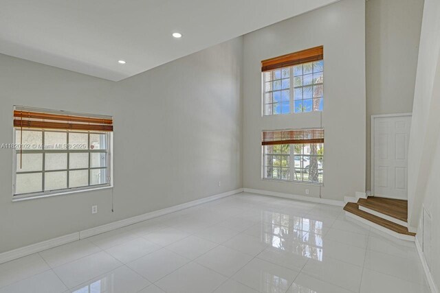 164 Granada Ave, Weston, FL 33326 - unfurnished room featuring healthy amount of natural light, tile patterned flooring, recessed lighting, and a towering ceiling