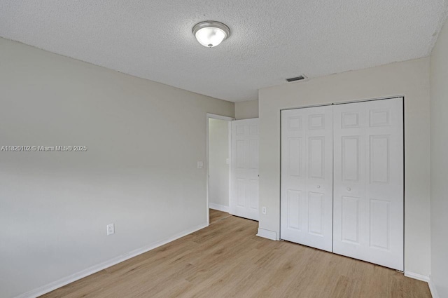 164 Granada Ave, Weston, FL 33326 - unfurnished bedroom featuring wood finished floors, a textured ceiling, and a closet