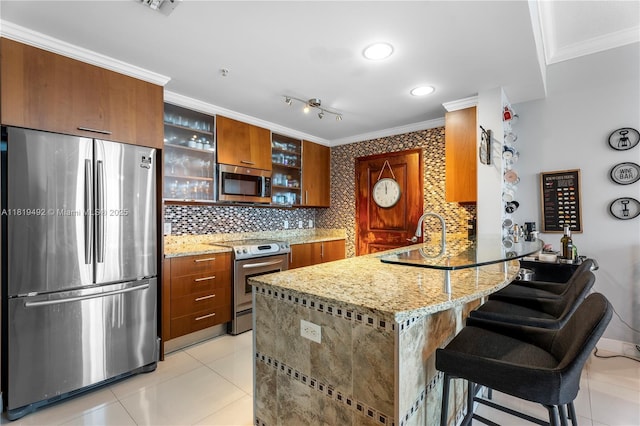 1945 S Ocean Dr Unit 2209, Hallandale Beach, FL 33009 - kitchen featuring appliances with stainless steel finishes, brown cabinetry, a peninsula, ornamental molding, and light tile patterned flooring