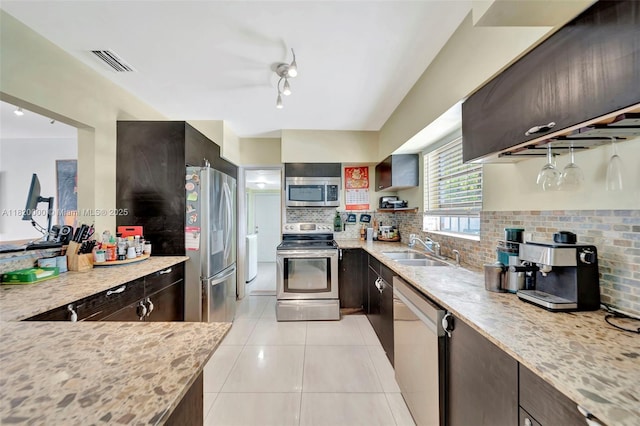14925 NE 7th Ave, Miami, FL 33161 - kitchen with stainless steel appliances, a sink, decorative backsplash, dark brown cabinets, and light tile patterned flooring