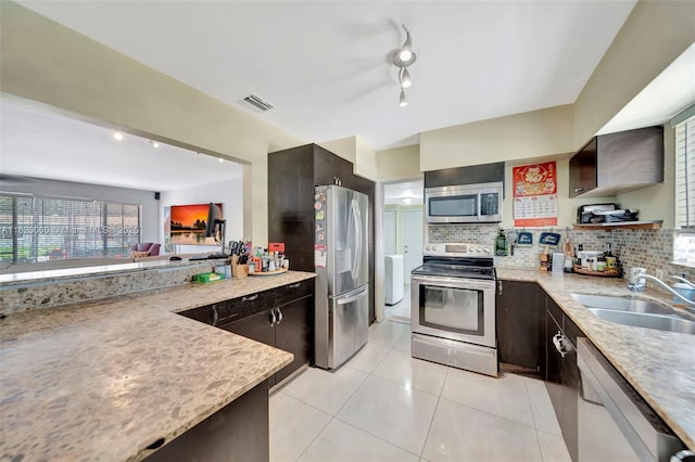 14925 NE 7th Ave, Miami, FL 33161 - kitchen with stainless steel appliances, a sink, decorative backsplash, light tile patterned floors, and dark brown cabinetry