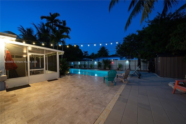 14925 NE 7th Ave, Miami, FL 33161 - pool at night with a sunroom, a patio area, and a fenced backyard