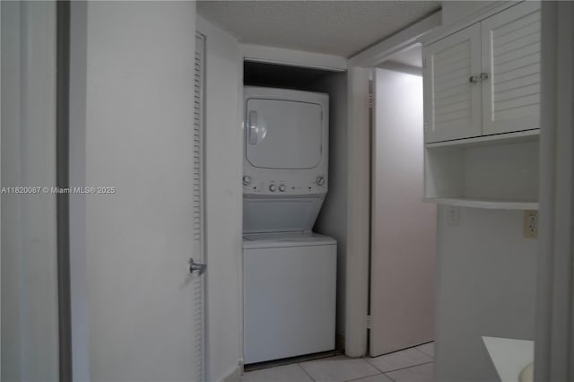 8365 SW 152nd Ave Unit C-104, Miami, FL 33193 - washroom featuring stacked washer / drying machine, light tile patterned floors, and a textured ceiling