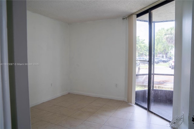 8365 SW 152nd Ave Unit C-104, Miami, FL 33193 - spare room featuring a textured ceiling, light tile patterned floors, and expansive windows