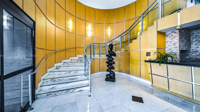 6770 Indian Creek Dr Unit 7B, Miami Beach, FL 33141 - staircase with a towering ceiling and a decorative wall