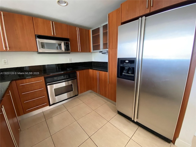 610 Clematis St Unit 721, West Palm Beach, FL 33401 - kitchen featuring appliances with stainless steel finishes, glass insert cabinets, light tile patterned floors, brown cabinetry, and recessed lighting