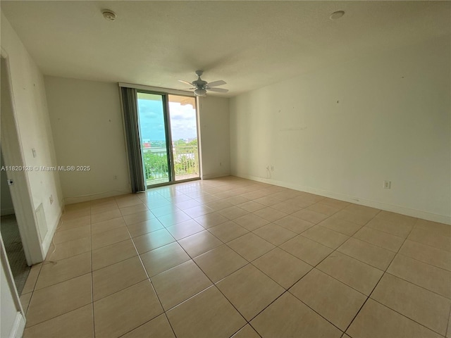610 Clematis St Unit 721, West Palm Beach, FL 33401 - spare room featuring light tile patterned flooring, ceiling fan, a smoke detector, and a wall of windows