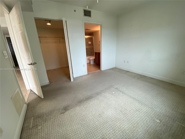 610 Clematis St Unit 721, West Palm Beach, FL 33401 - unfurnished bedroom with light colored carpet, a spacious closet, a closet, and ensuite bath