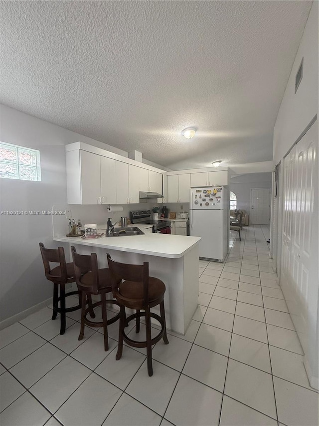 2413 W 73rd Pl, Hialeah, FL 33016 - kitchen featuring freestanding refrigerator, electric range oven, light countertops, a peninsula, and a textured ceiling