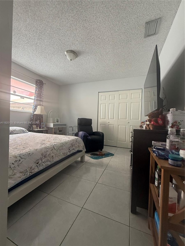 2413 W 73rd Pl, Hialeah, FL 33016 - bedroom featuring a closet, light tile patterned floors, and a textured ceiling