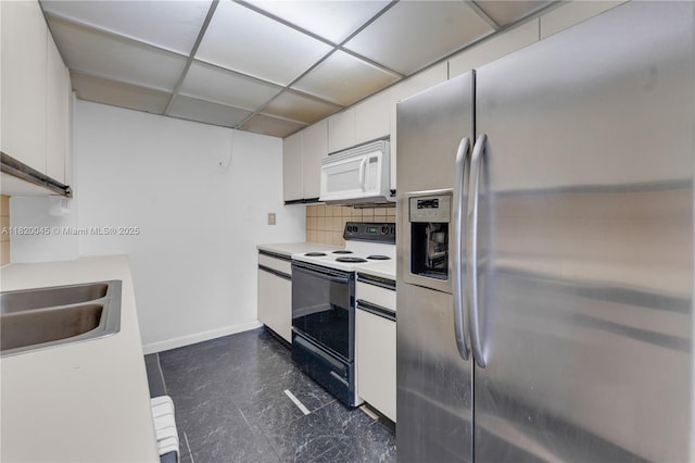 2457 Collins Ave Unit 201, Miami Beach, FL 33140 - kitchen featuring stainless steel fridge, range with electric stovetop, white microwave, white cabinets, and backsplash