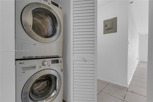 2457 Collins Ave Unit 201, Miami Beach, FL 33140 - washroom featuring stacked washer and clothes dryer, electric panel, light tile patterned floors, and baseboards