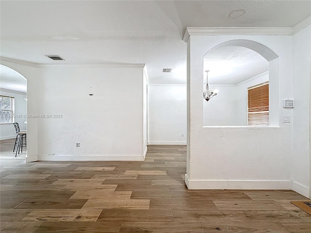 3506 SW 171st Ave, Miramar, FL 33027 - empty room featuring crown molding, wood finished floors, arched walkways, and a chandelier