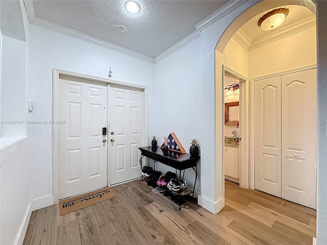 3506 SW 171st Ave, Miramar, FL 33027 - entrance foyer featuring arched walkways, crown molding, light wood-style flooring, a textured ceiling, and a textured wall