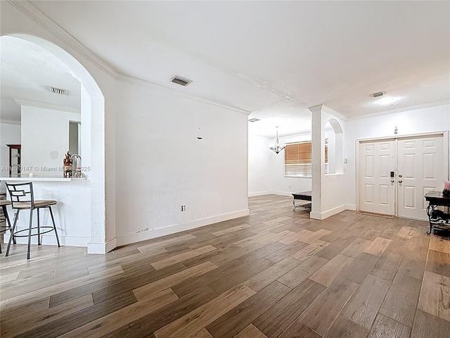3506 SW 171st Ave, Miramar, FL 33027 - unfurnished living room with crown molding, arched walkways, wood finished floors, and a chandelier