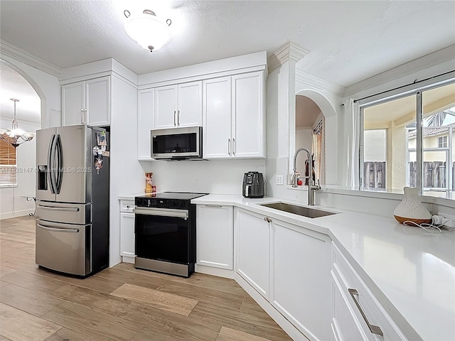 3506 SW 171st Ave, Miramar, FL 33027 - kitchen featuring stainless steel appliances, arched walkways, light wood-type flooring, white cabinetry, and light countertops