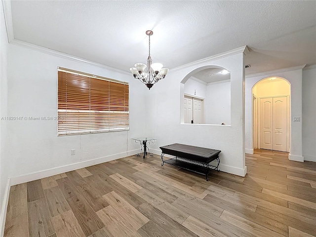 3506 SW 171st Ave, Miramar, FL 33027 - spare room featuring ornamental molding, arched walkways, wood finished floors, and a chandelier