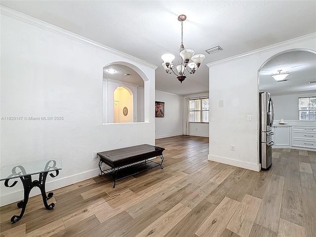 3506 SW 171st Ave, Miramar, FL 33027 - empty room featuring ornamental molding, arched walkways, a chandelier, plenty of natural light, and wood finished floors