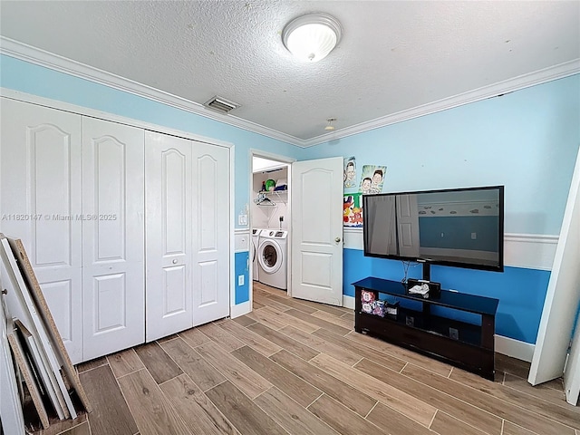 3506 SW 171st Ave, Miramar, FL 33027 - bedroom featuring independent washer and dryer, wood finish floors, a closet, ornamental molding, and a textured ceiling