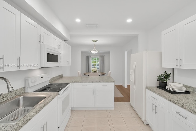 6561 SW 18th St, West Miami, FL 33155 - kitchen featuring white appliances, a peninsula, white cabinetry, light tile patterned flooring, and hanging light fixtures
