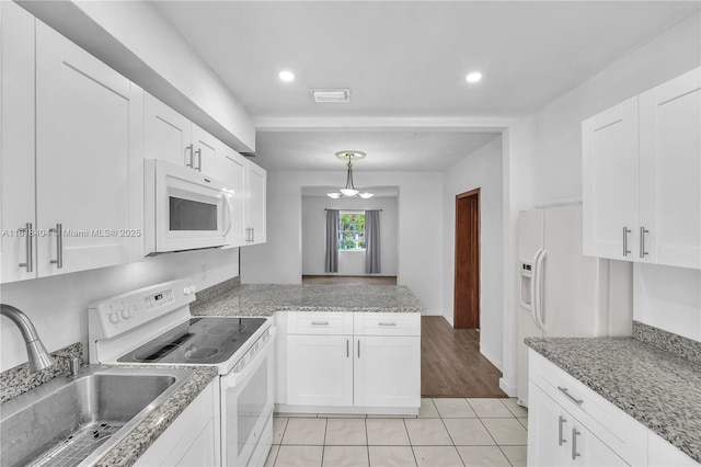 6561 SW 18th St, West Miami, FL 33155 - kitchen with white appliances, white cabinets, a peninsula, a chandelier, and recessed lighting