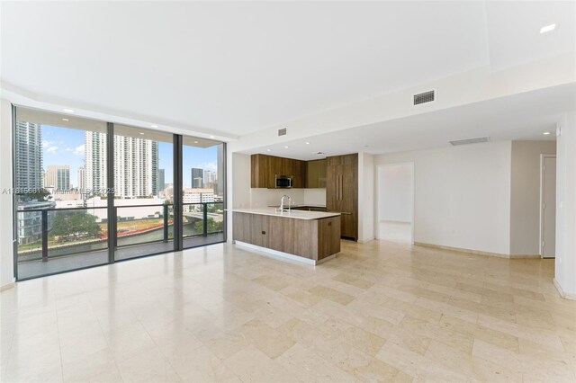 88 SW 7th St Unit 712, Miami, FL 33130 - kitchen with open floor plan, stainless steel microwave, light countertops, a wall of windows, and a view of city