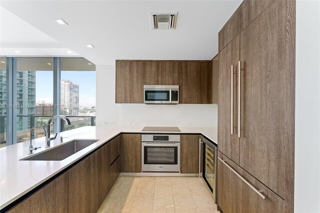 88 SW 7th St Unit 712, Miami, FL 33130 - kitchen with stainless steel appliances, modern cabinets, beverage cooler, light countertops, and recessed lighting