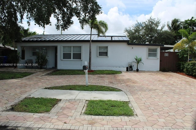 6810 Douglas St, Hollywood, FL 33024 - view of front of home with stucco siding, a standing seam roof, and a metal roof